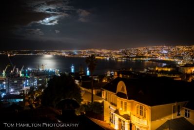 a full moon rises over Valparaiso's busy harbor